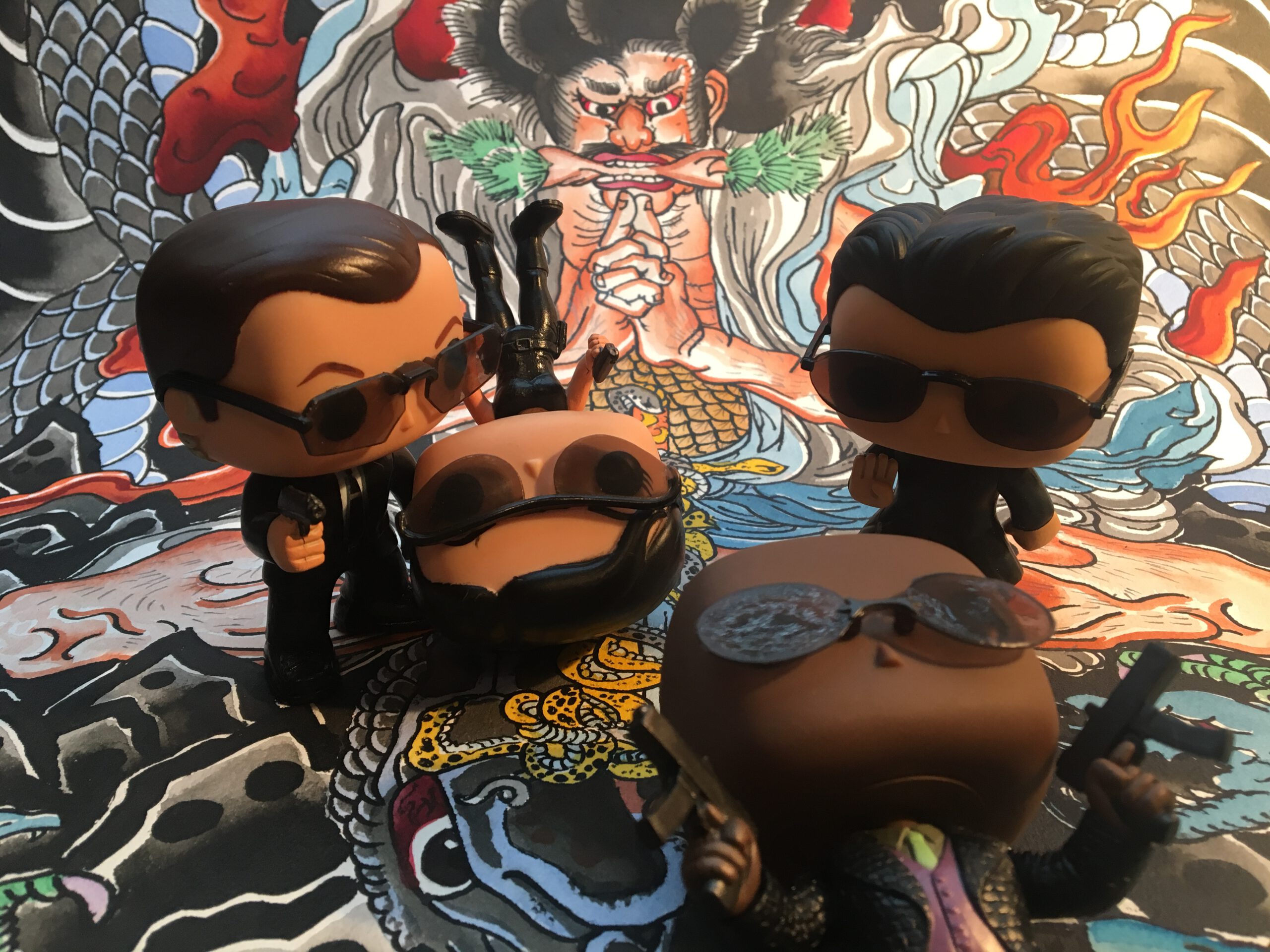 Four Funko Pop figures from the matrix movie in front of the Kidumaru painting by Gordon Claus