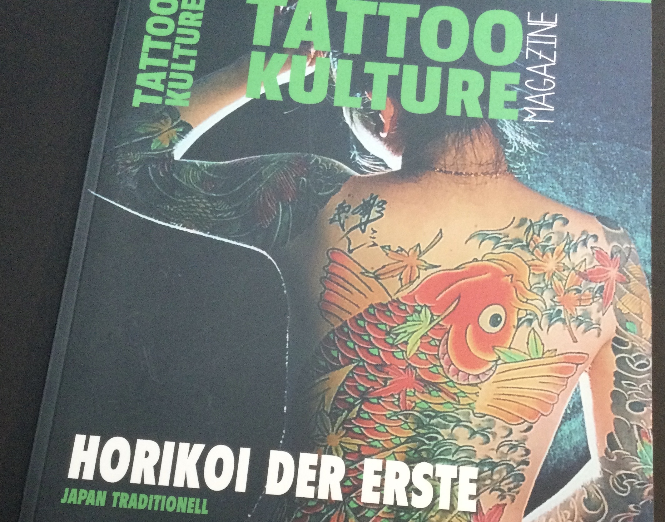 A woman’s back decorated with koi fish on magazine cover