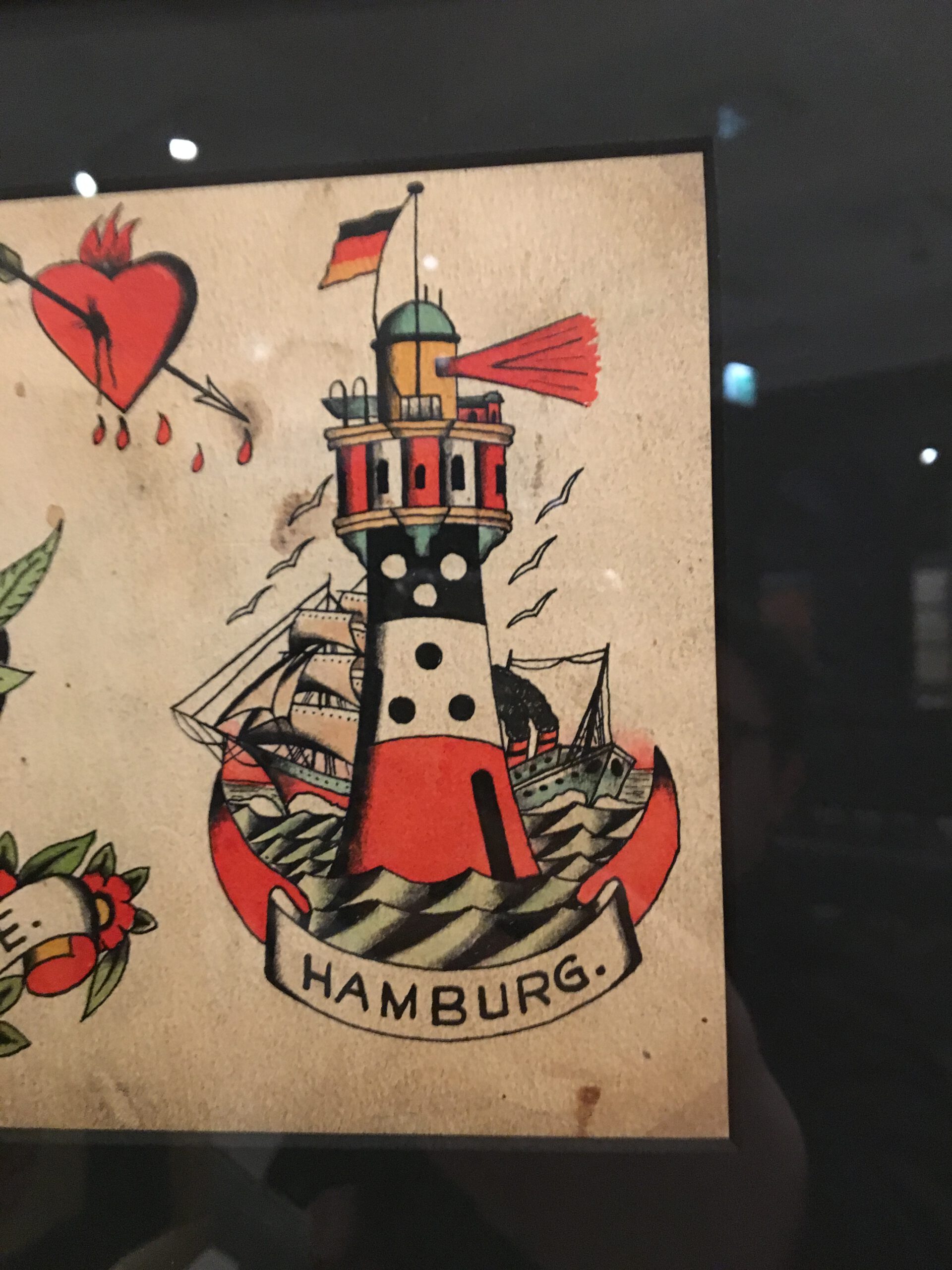 Teil eines wunderschönen Bogens von Christian wahrlich mit einem Leuchtturm in drei Farben und eine Banderole Hamburg unten drunter.