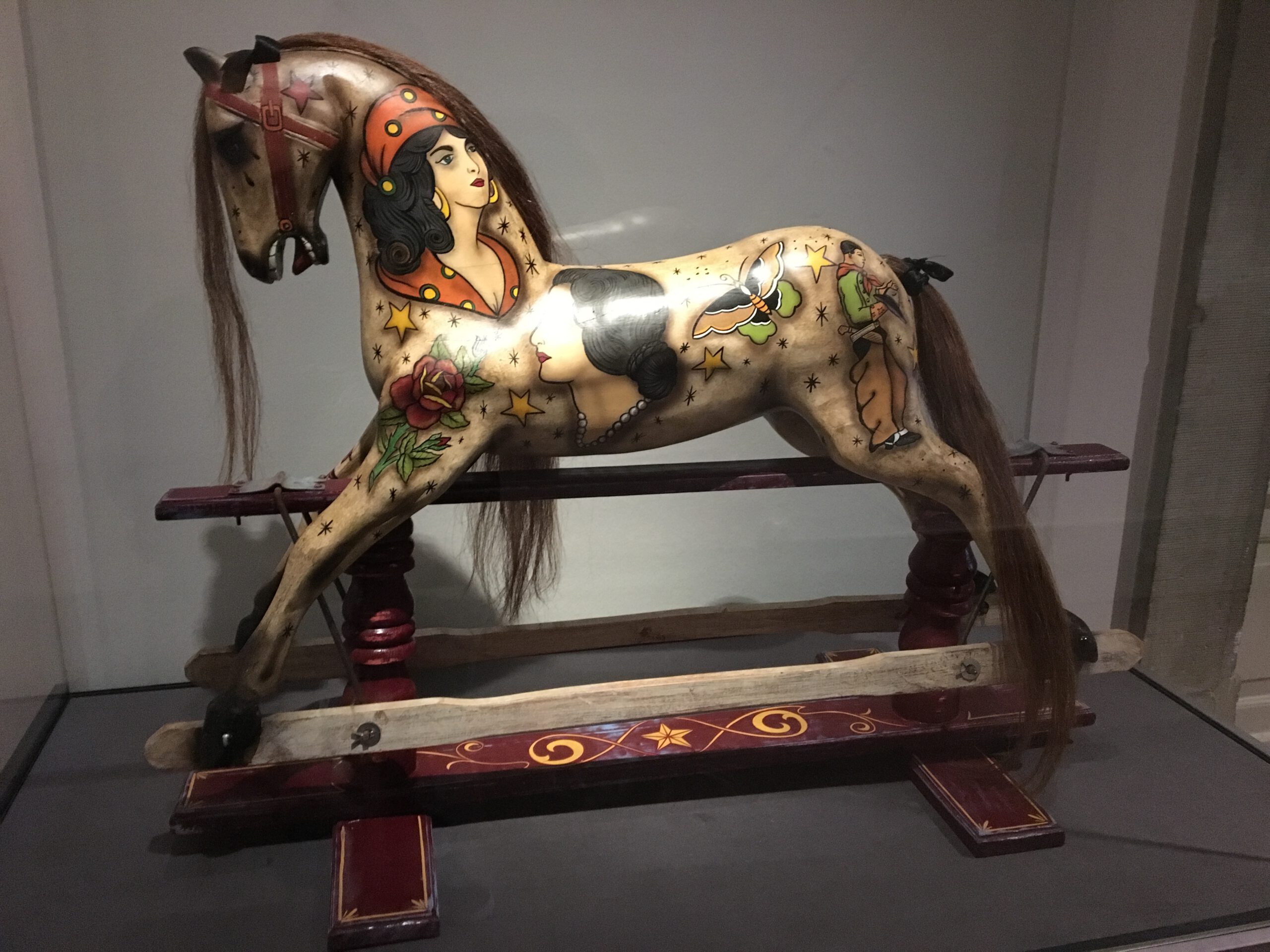 A rocking horse for children with tattoo designs all over.the wood is beautifully worked and it seems to be polished.multiple layers of different ward.it seems that it is from the time with people didn’t watch too much television and spend hours working for perfection