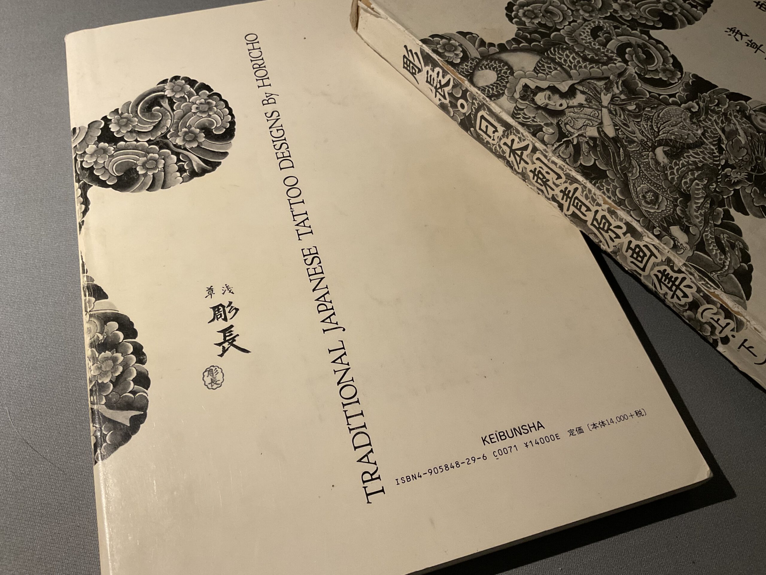 Buch cover von dem Japanischem Tätowier meister Horicho. Japanische sowie Romanische Schrift ist zu erkennen. In allem ist das Buch Cover nur weiß mit Schrift.