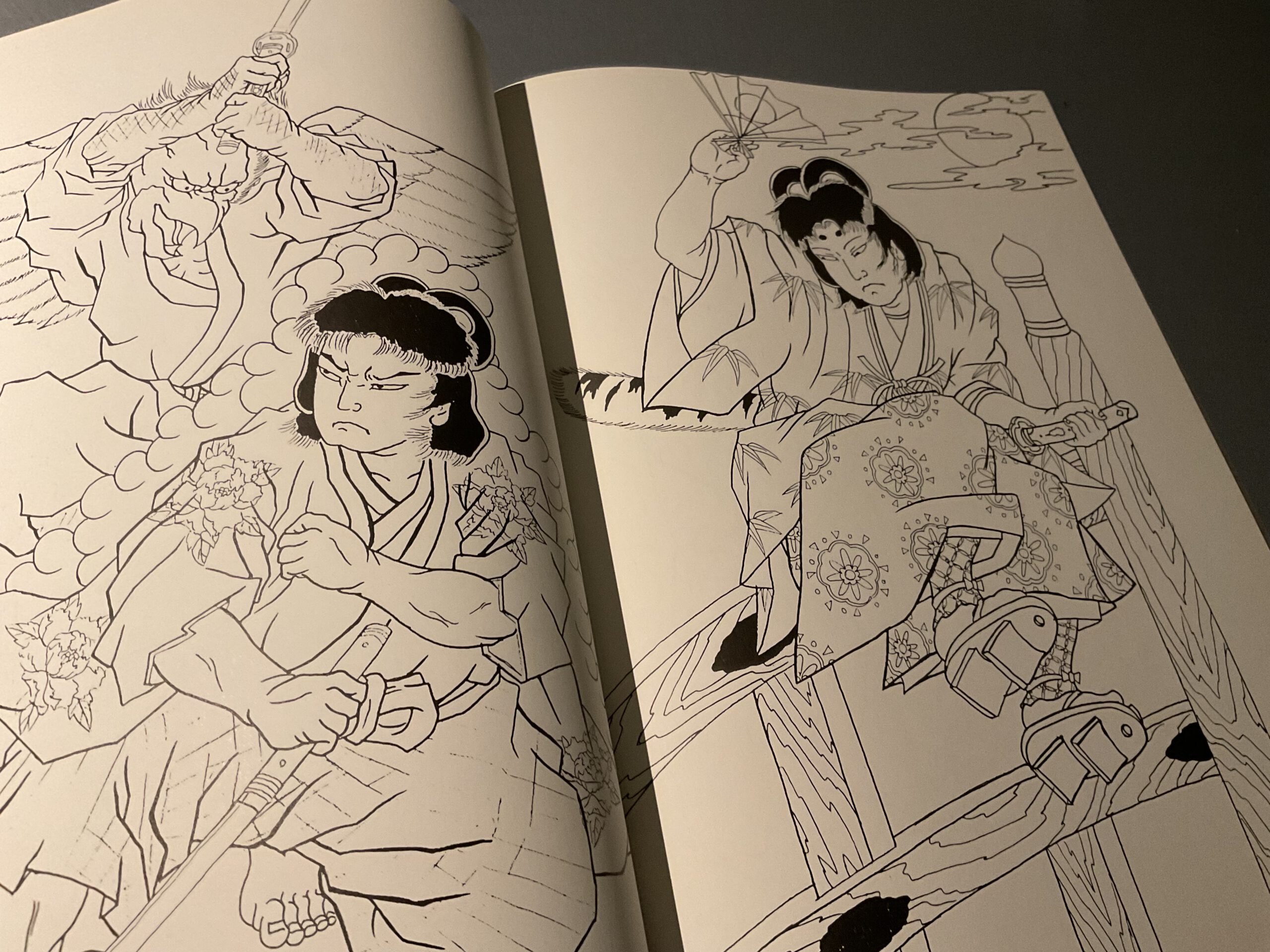 Buch Ausschnitt von dem Schnitzenden Cho. Horicho hat hier den Helden Ushiwakamaru dargestellt. Der glorifizierte Bullen junge. Der Junge übt mit Waldwesen, seine Kampfkunst. In dem Bild auf der rechten Seite des Buches wird er auf einer Brücke dargestellt.  