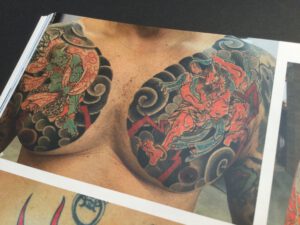 God of Thunder and God of wind tattooed on chest panels of a man.