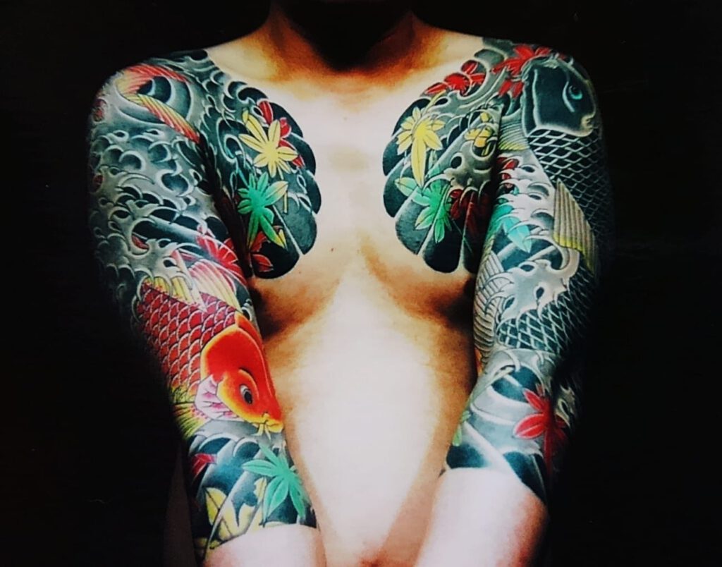 tattooed arms. Tattooed chest. both with carp and maple leaves.