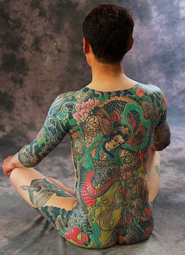 A mans complete back filled with Heavenly Maiden and Background. The man sits in warrior pose.