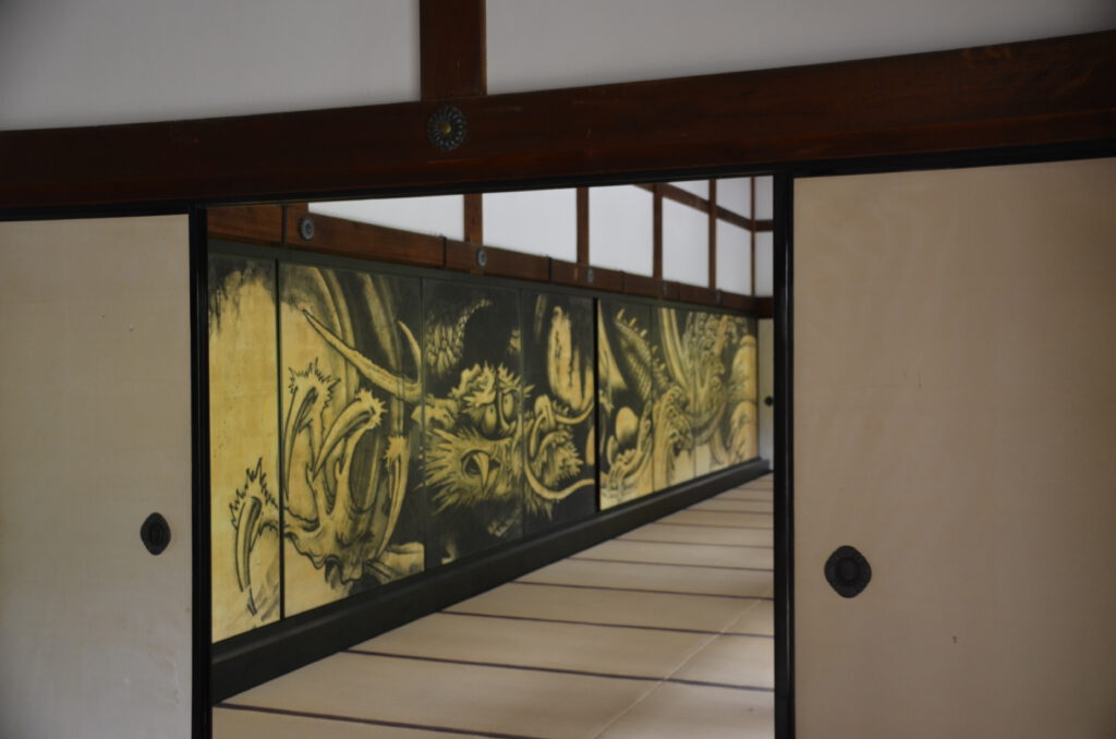 view between doors of Unryuzu painted at Tenryu-ji Temple grounds near Arashiyama, Japan. Dragon painted on wall.