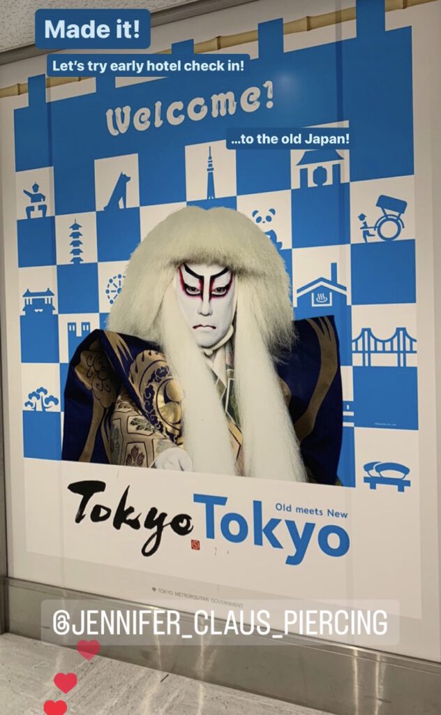 Described Feelings and trip information on foto showing the head and body of an noh theather actor. faace make-up with red lines going up around the eyes. the male is wearing a large white wig depicting one of two lions from the play "Renshishi". Usually the other figure has a red wig. Red and White being the flag of Japan.