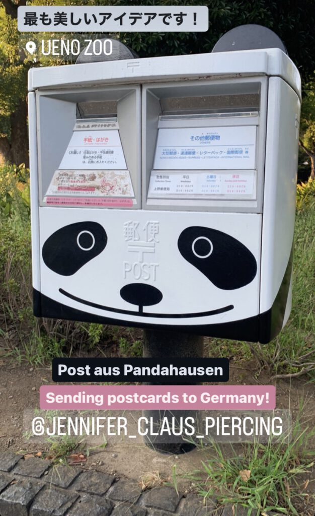 Ueno Zoo Postbox with panda bear face painted on in White and Black by town council. Bushes in the back. It´s not unusual to see this around famous spots through out Japan.