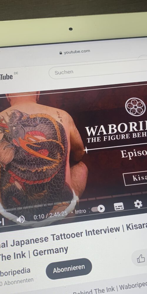 I phone showing content of a interview with Kisaragi the second for “Waboripedia” japanese interview series. On the left hand side you can see a sitting man with a dragon tattooed on his back.